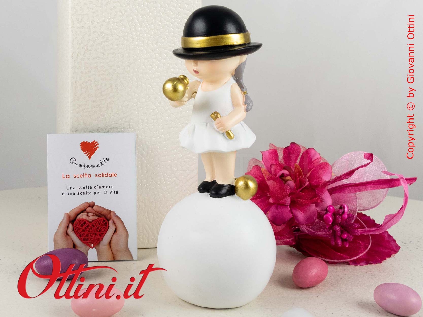 D6833 - La Monella su Palla con Cappellino nero di Cuorematto è una bomboniera solidale per ragazze completa di confezione.