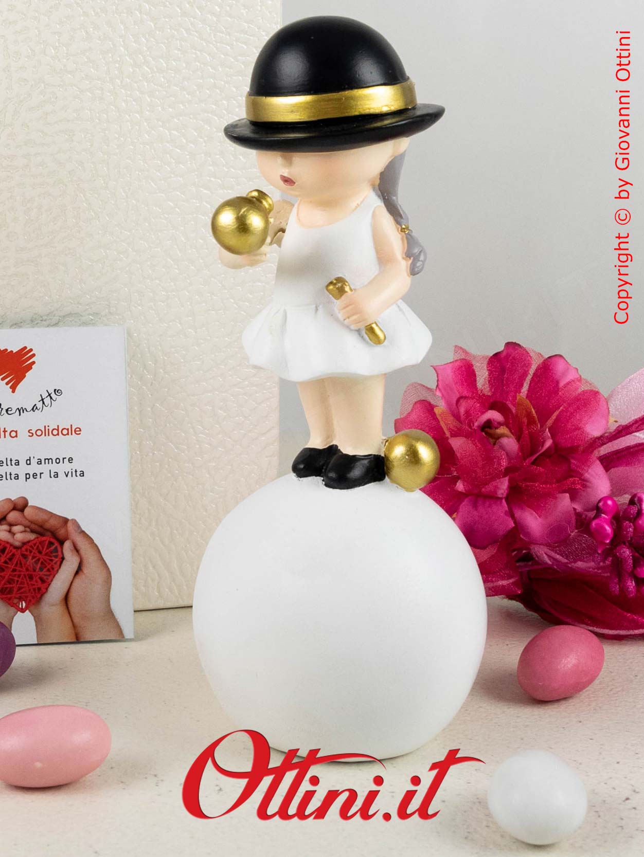 D6833 - La Monella su Palla con Cappellino nero di Cuorematto è una bomboniera solidale per ragazze completa di confezione.