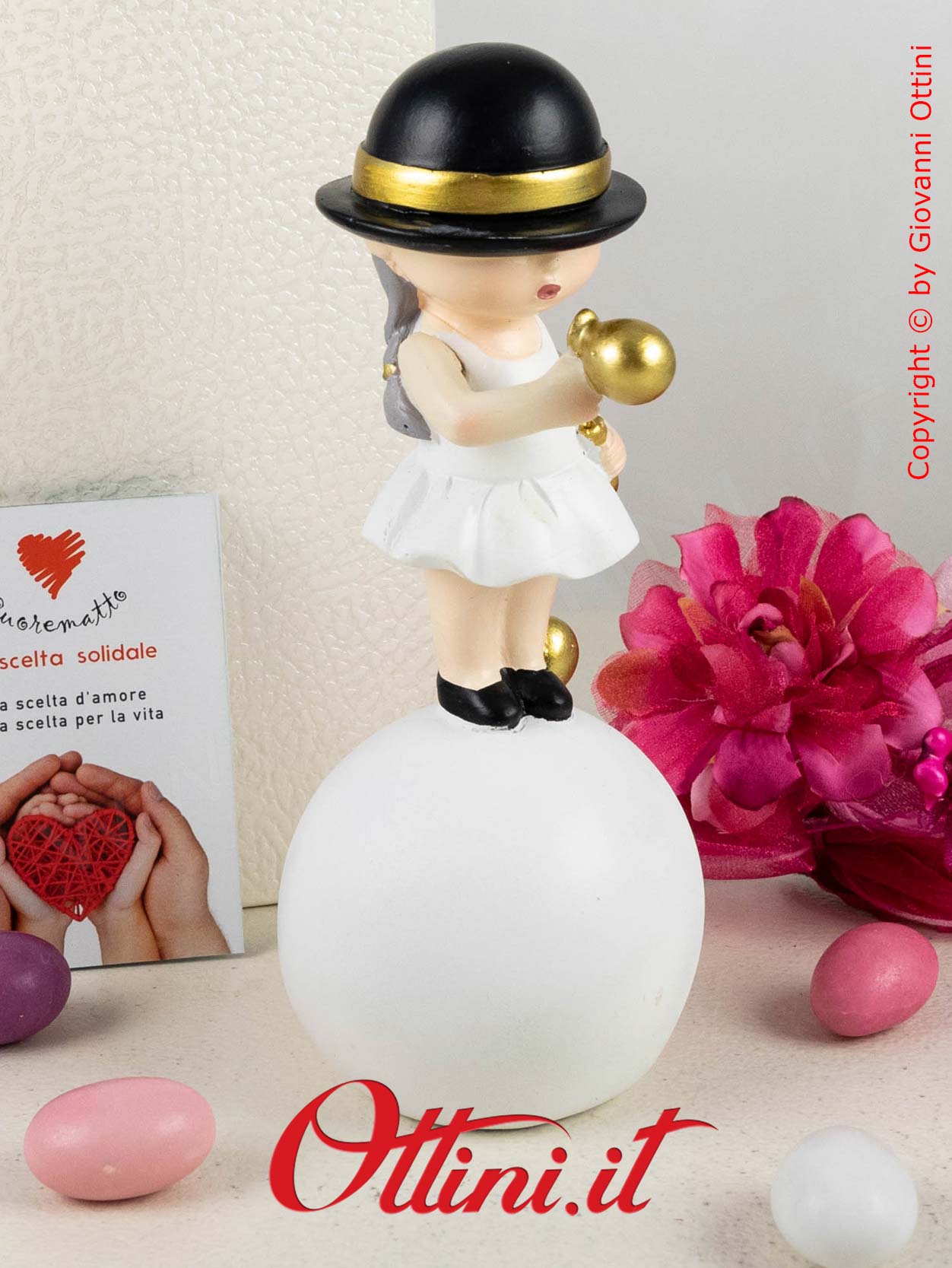 D6833 - La Monella su Palla con Cappellino nero di Cuorematto è una bomboniera solidale per ragazze completa di confezione.