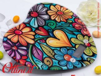 D9156 La Bilancia a forma di cuore con Fiori Colorati di Cuorematto è una bomboniera solidale utile in cucina, con colori vivaci, antigraffio. Pila Inclusa