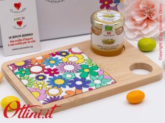 DA197 - il Tagliere rettangolare Fiorello con miele di Cuorematto è una bomboniera solidale utile in cucina con colori floreali vivaci, antigraffio.