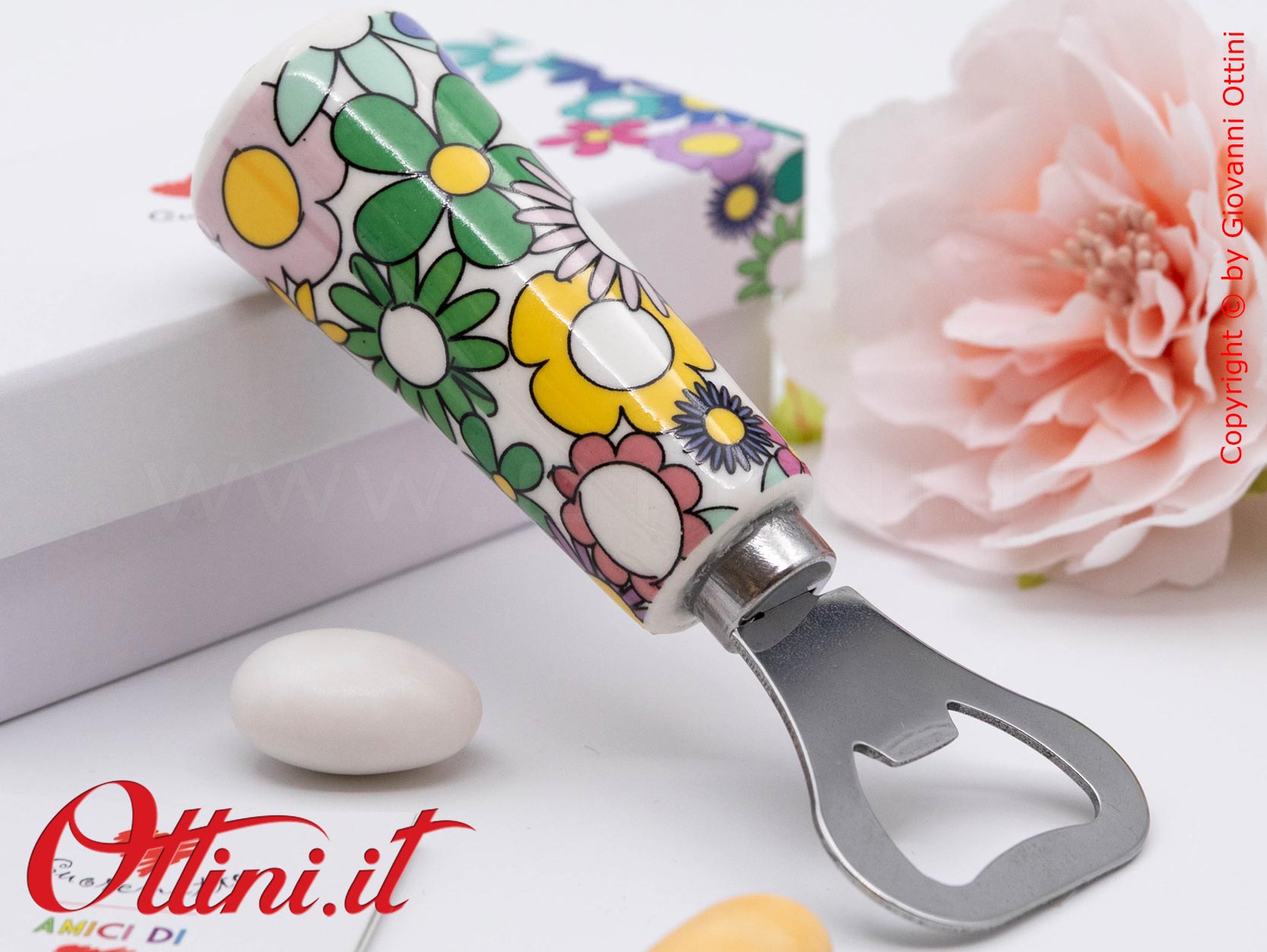 DA203 - l'Apribottiglia Fiorello di Cuorematto è una bomboniera solidale utile a tavola, caratterizzato da colori floreali vivaci e un design esclusivo