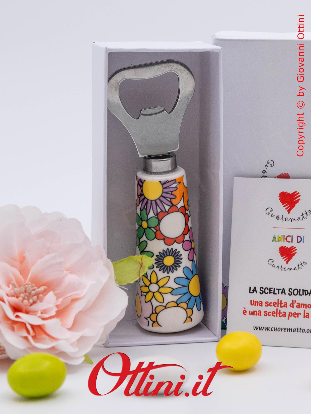 DA203 - l'Apribottiglia Fiorello di Cuorematto è una bomboniera solidale utile a tavola, caratterizzato da colori floreali vivaci e un design esclusivo